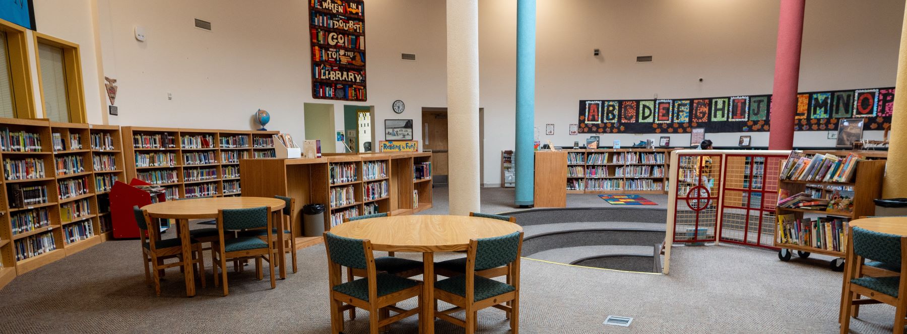 A school library filled with tables and chairs, perfect for studying and reading in a quiet space.