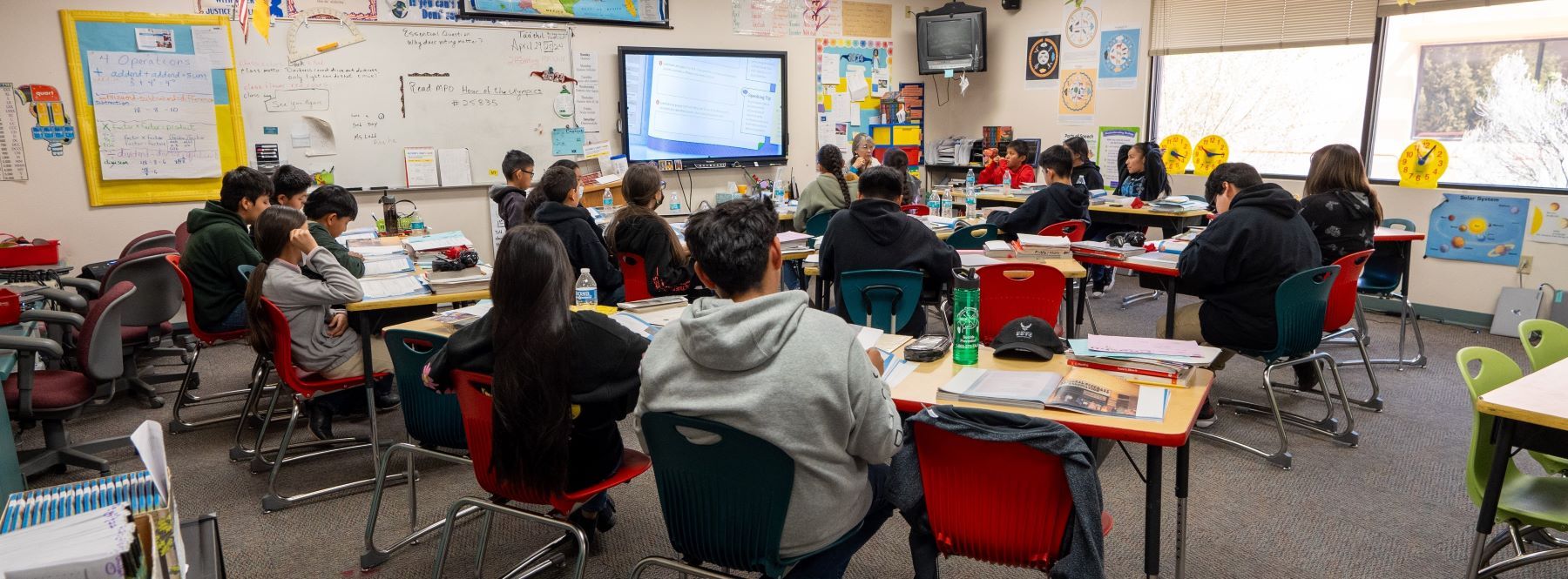 A classroom filled with students seated at desks, focused on their work and engaged in learning activities.