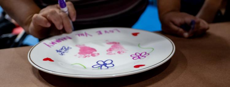 A child's handprint in bright colors decorates a round plate, highlighting a fun art project.