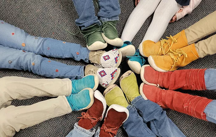 Photo of small kids shoes touching in a circle. 